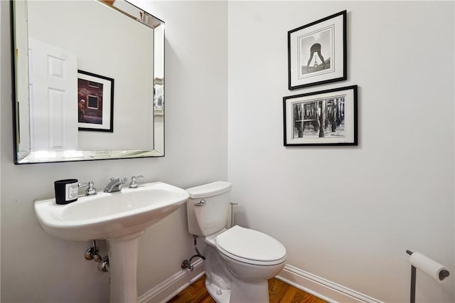 bathroom with hardwood / wood-style floors and toilet