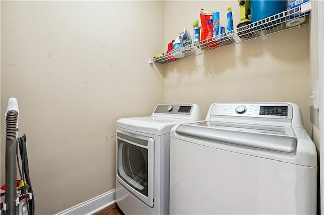 clothes washing area featuring hardwood / wood-style floors and washing machine and dryer