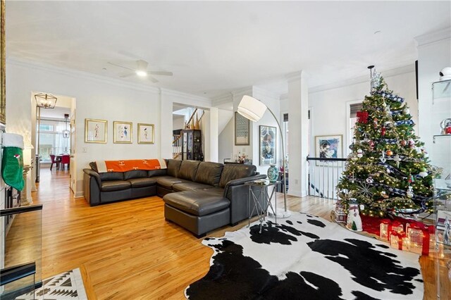 living room featuring hardwood / wood-style floors, ceiling fan, and crown molding