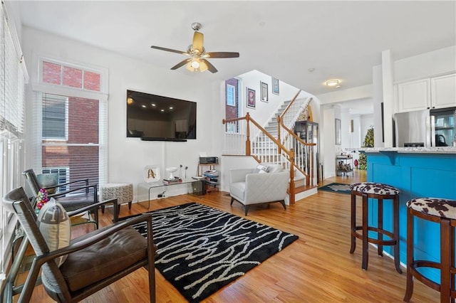 living room featuring light hardwood / wood-style flooring and ceiling fan