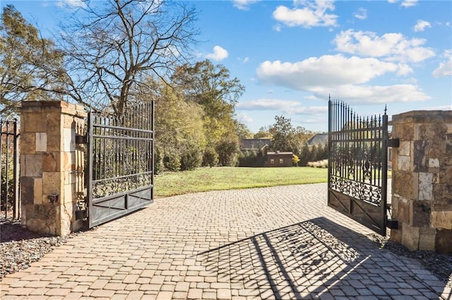 view of gate with a yard