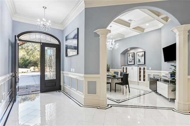 entrance foyer featuring french doors, coffered ceiling, an inviting chandelier, beamed ceiling, and crown molding