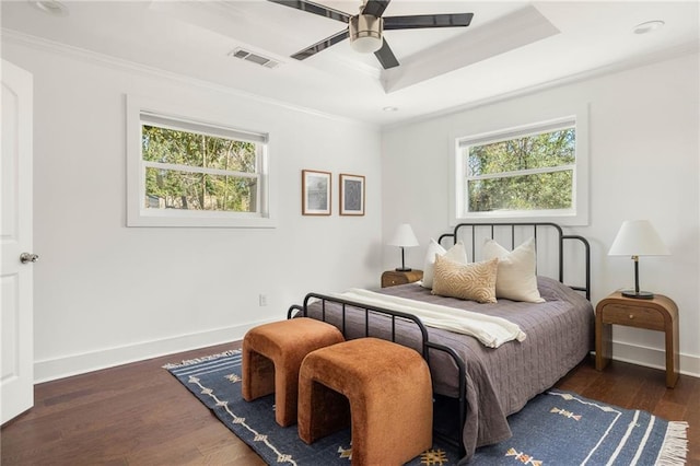 bedroom featuring visible vents, multiple windows, a raised ceiling, and ornamental molding