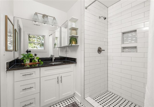 full bath featuring vanity and tiled shower