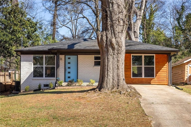 view of front of home featuring a front yard, central air condition unit, fence, and brick siding