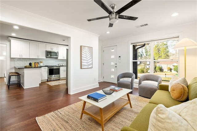 living area with dark wood-style floors, visible vents, recessed lighting, and ornamental molding