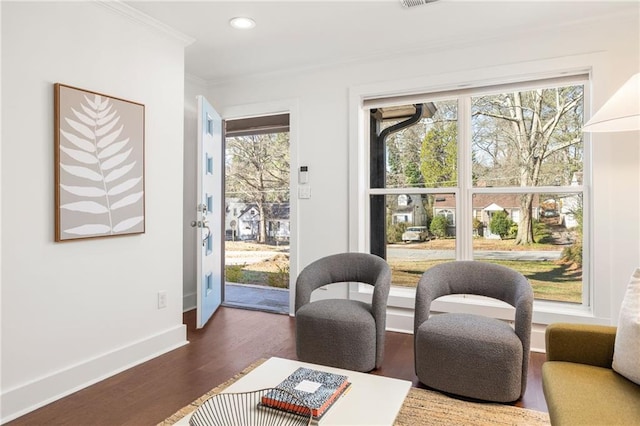 living area with crown molding, dark wood-style floors, baseboards, and a wealth of natural light