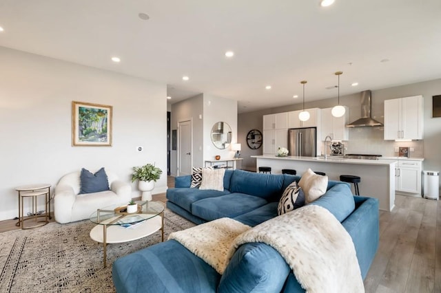 living room featuring sink and light hardwood / wood-style flooring