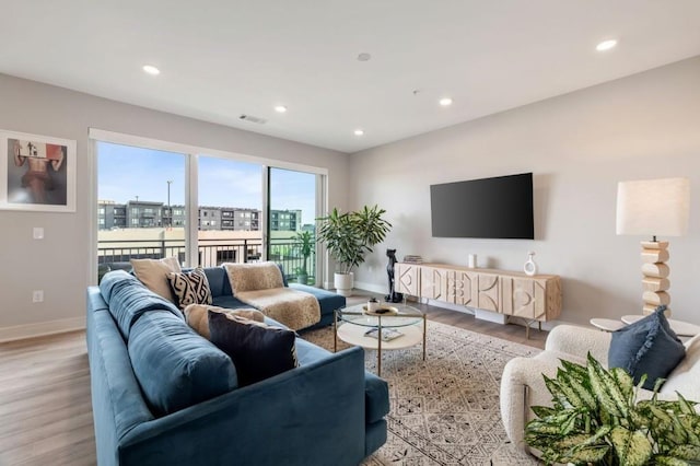 living area with recessed lighting, visible vents, and wood finished floors