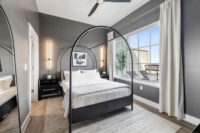 bedroom with ceiling fan, baseboards, and wood finished floors