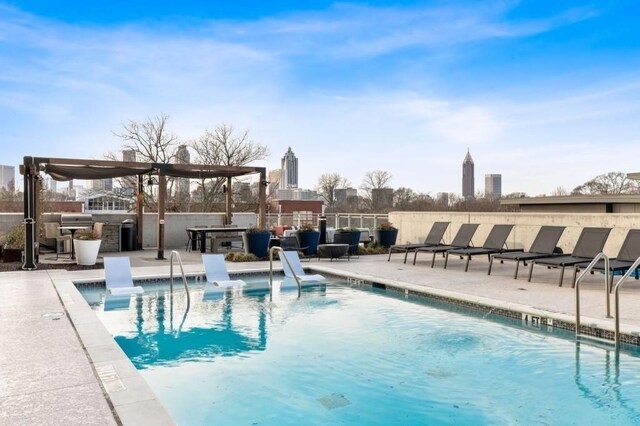 community pool with a patio and outdoor dry bar