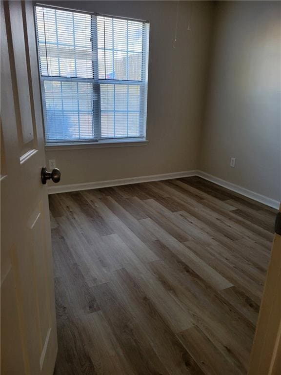 unfurnished room with baseboards and wood finished floors