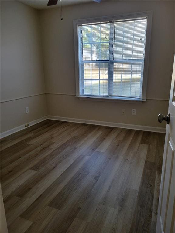 spare room featuring baseboards, ceiling fan, and wood finished floors