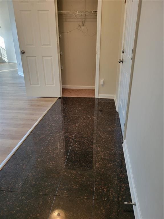 unfurnished bedroom with a closet, baseboards, and granite finish floor