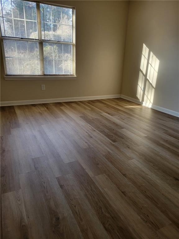 spare room featuring wood finished floors and baseboards