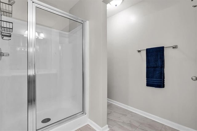 bathroom with a shower stall, marble finish floor, and baseboards