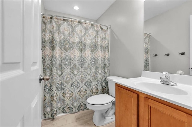 bathroom featuring toilet, vanity, and a shower with curtain