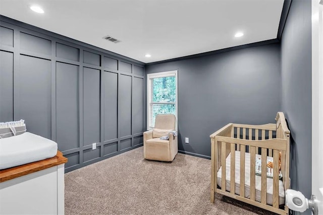 bedroom with a crib, carpet, visible vents, and recessed lighting