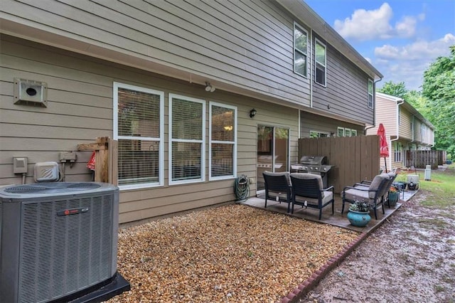 back of house with central AC unit, fence, and a patio