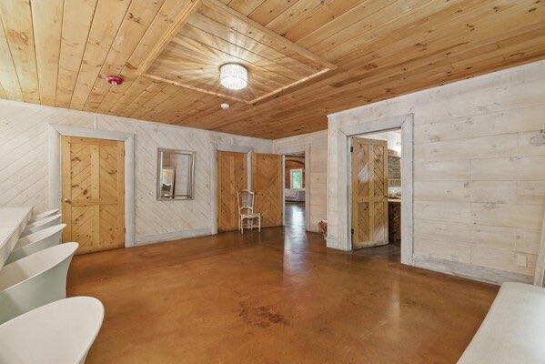 230 Old Mill White Ext, Jasper, GA 30143 - unfurnished living room featuring wood ceiling, concrete floors, and wood walls