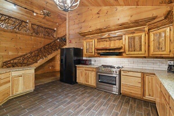 230 Old Mill White Ext, Jasper, GA 30143 - kitchen featuring black refrigerator with ice dispenser, high end stainless steel range oven, wooden ceiling, light countertops, and high vaulted ceiling