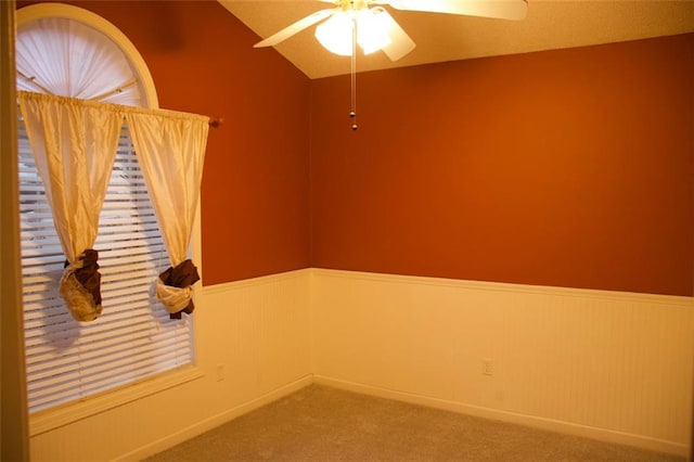 spare room with lofted ceiling, carpet floors, and ceiling fan