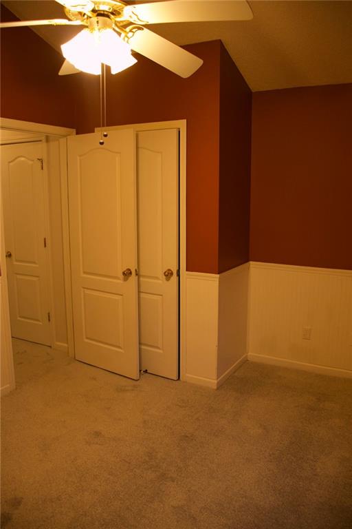 unfurnished bedroom with ceiling fan and carpet floors