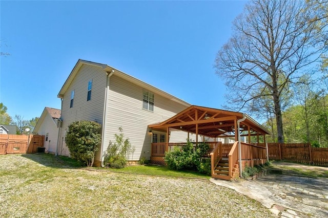 rear view of house with a patio area, a lawn, and a deck