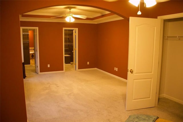 unfurnished bedroom featuring ornamental molding, a walk in closet, carpet floors, and a closet