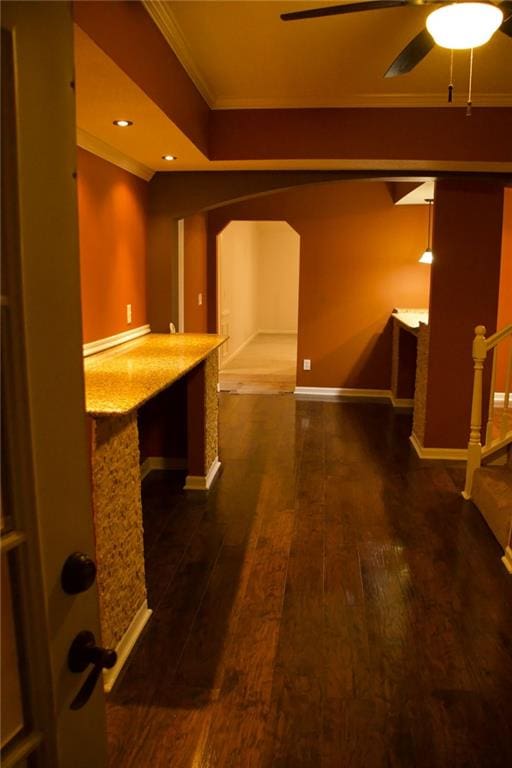 corridor with dark wood-type flooring and ornamental molding