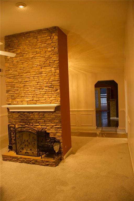 unfurnished living room featuring carpet flooring and a fireplace