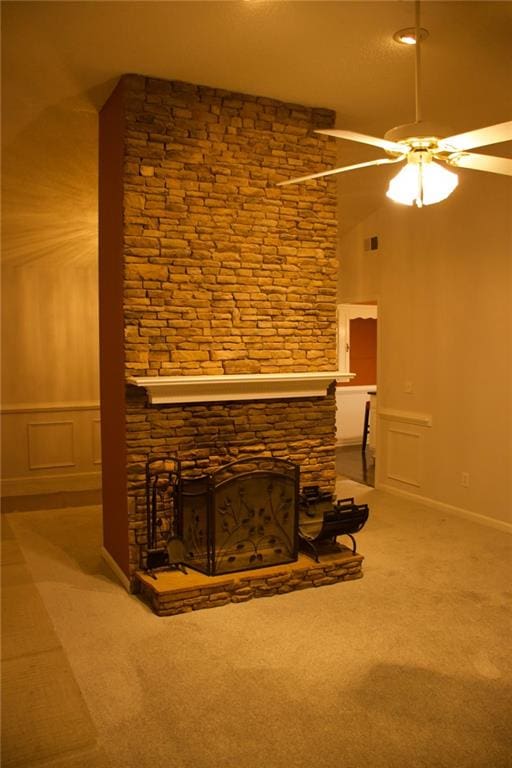 unfurnished living room with a fireplace, ceiling fan, and carpet