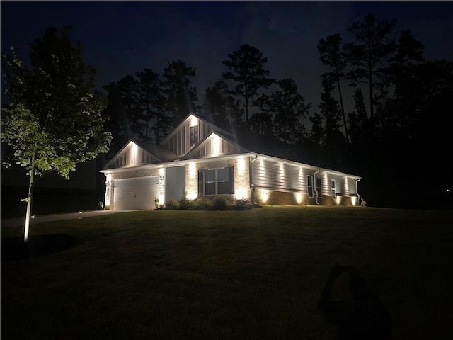 view of front facade with driveway, a garage, and a yard