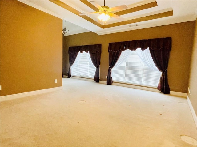 spare room with ceiling fan, a raised ceiling, and carpet floors