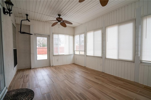 unfurnished sunroom featuring ceiling fan