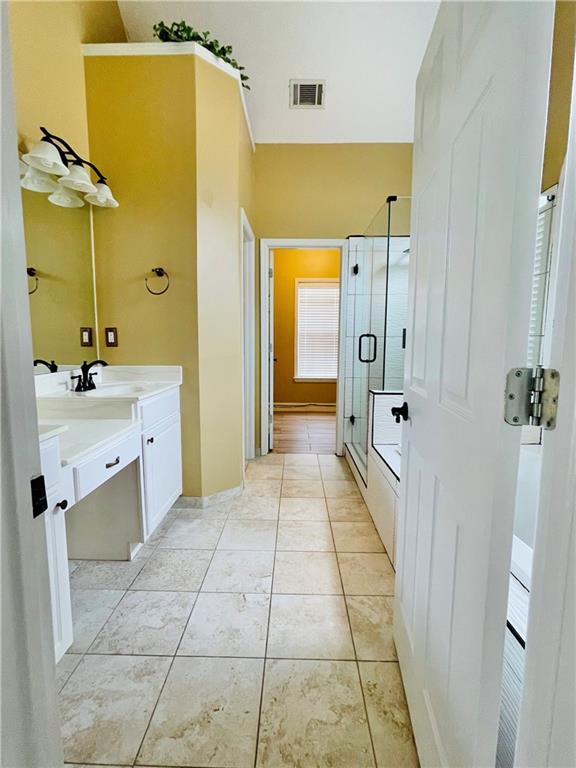 bathroom with walk in shower, tile patterned floors, and vanity