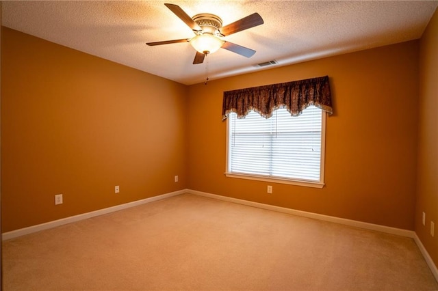 carpeted spare room featuring ceiling fan and a textured ceiling