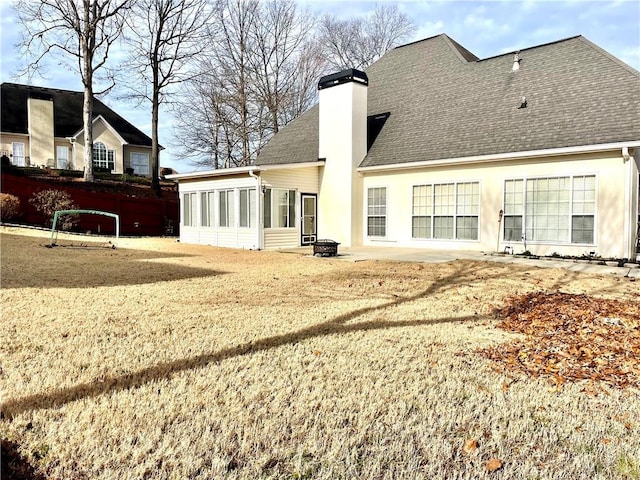 back of house with a sunroom and a yard