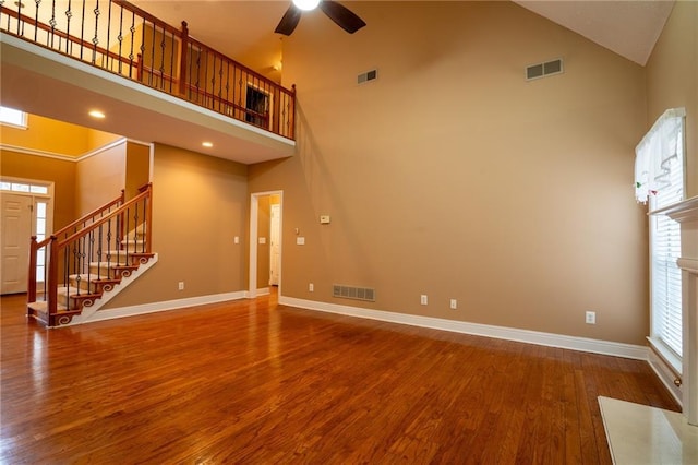 unfurnished living room featuring ceiling fan, high vaulted ceiling, and hardwood / wood-style floors