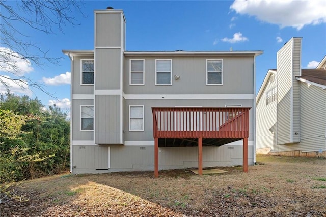 back of house with crawl space, a deck, and a chimney