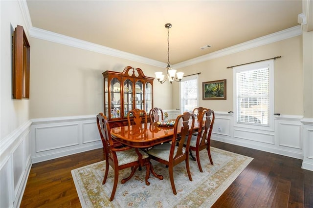 dining room featuring an inviting chandelier, dark wood finished floors, and ornamental molding