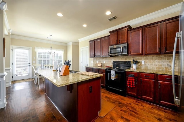 kitchen with stainless steel microwave, dark brown cabinets, visible vents, a center island, and black range with electric stovetop