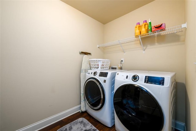 clothes washing area featuring washer and dryer, laundry area, dark wood-style floors, and baseboards