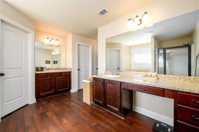 bathroom with visible vents, a stall shower, wood finished floors, baseboards, and vanity