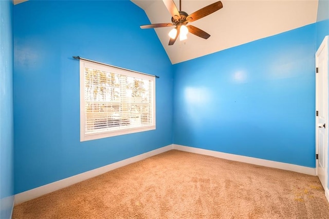 carpeted empty room featuring vaulted ceiling, baseboards, and ceiling fan