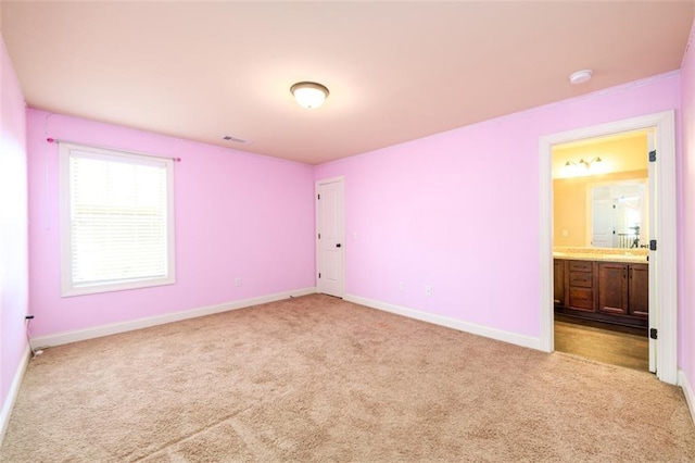 unfurnished bedroom with ensuite bathroom, visible vents, baseboards, and carpet floors