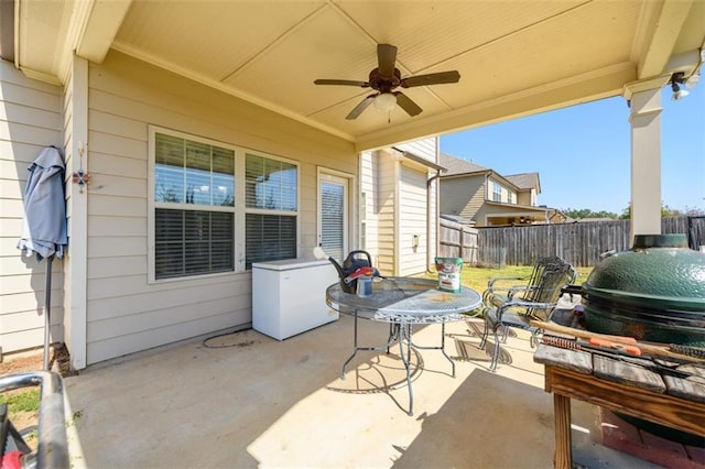 view of patio featuring outdoor dining area, ceiling fan, and fence