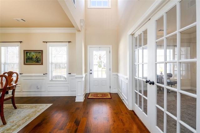 foyer entrance with dark wood-type flooring, french doors, visible vents, and ornamental molding