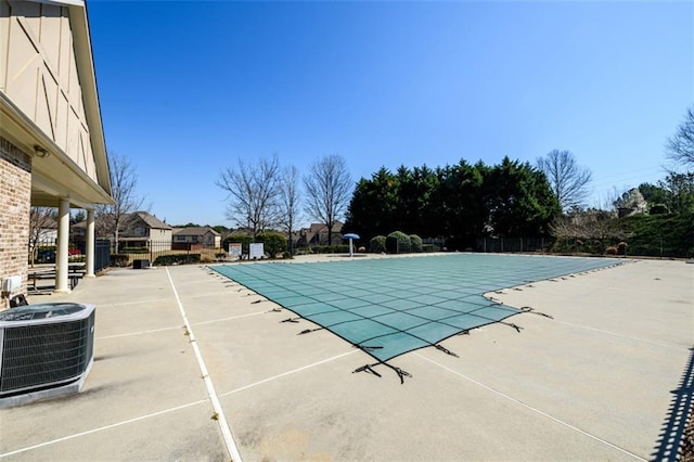 community pool featuring a patio area, central AC, and fence