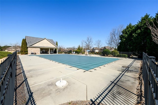 community pool with a patio and fence